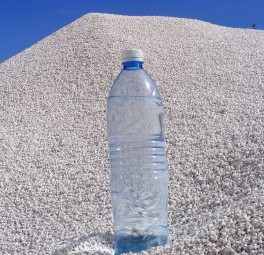 בקבוק מים מפלסטיק המונח על תל של חצץ או אבן מרוסקת לבנה