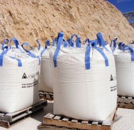 שקי אחסון תעשייתיים לבנים גדולים מהודקים ברצועות כחולות ומאוחסנים בחוץ