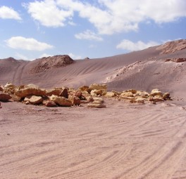 נוף מחצבה מדברי עם משקעי מינרלים בהירים וגבעות סלעיות