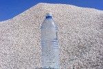 ערימה גדולה של חצץ או אגרגט מינרלי בהיר בשטח פתוח, עם בקבוק פלסטיק מונח מעל לצורך קנה מידה